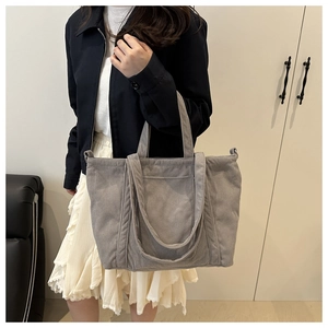 Detailed texture of grey corduroy tote bag showing vertical ribbed fabric on shoulder strap