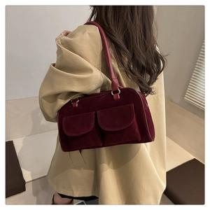 Detail of burgundy velvet shoulder bag showing texture and large front flap pockets