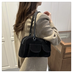 Detail of vintage black suede underarm bag with double front flap pockets and slim strap