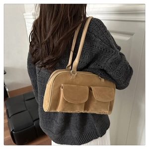 Back view of model wearing khaki suede shoulder bag with dual flap pockets detail