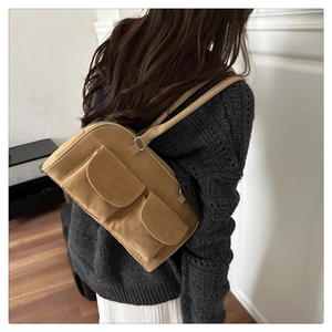 Gros plan d'un sac à bandoulière en daim vintage camel avec deux poches avant