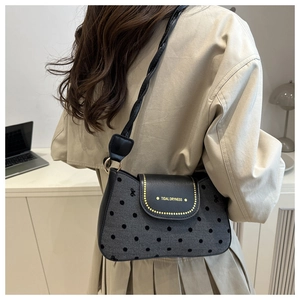 Détail du sac bandoulière en denim à pois avec rabat en cuir et logo tidal dryness