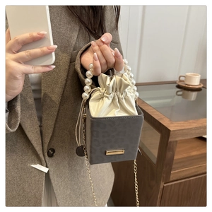 Detail of leopard texture mini bag featuring pearl handle and drawstring inner pouch