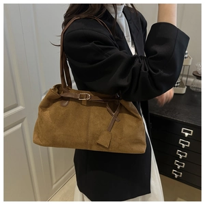 Vue détaillée du sac cabas en daim marron montrant sa texture souple et sa fine bandoulière