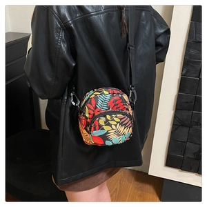 Detail of vibrant tropical leaf print crossbody bag with adjustable nylon shoulder strap