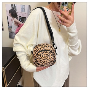 Leopard print crossbody bag shown worn by model with adjustable nylon shoulder strap