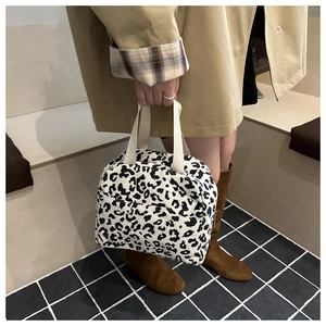 Detailed macro view of black and white leopard print corduroy lunch bag with dual handles