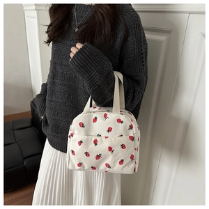 Detail of cute strawberry print on cream canvas lunch bag with front pocket
