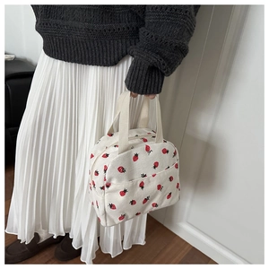 Detail of strawberry print corduroy lunch bag with dual handles and zipper closure