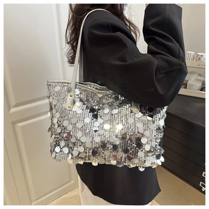 Dettaglio di grandi paillettes argento sulla borsa tote con lucentezza metallica
