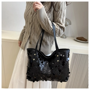 Detail of black sequined tote bag featuring large round sequins and gold rivet hardware