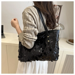 Detail showing high-capacity black sequin tote bag on shoulder with shimmering texture