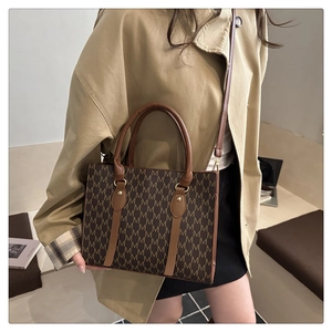 Detail view of the vintage monogram tote bag featuring leather handles and shoulder strap
