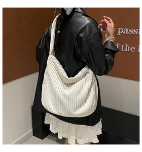 Detail of white corduroy tote bag with vertical striped texture and wide shoulder strap