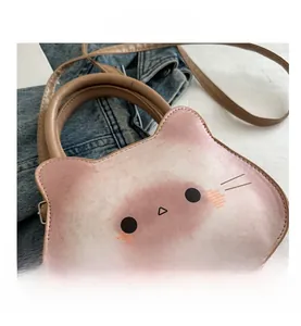 Detail shot of cute cat-shaped crossbody bag with pink gradient finish on denim