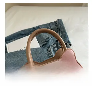 Close-up of the round handle and cute pink cat-shaped bag details with artistic props