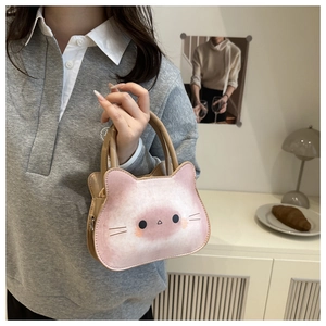 Détail du sac à main chat rose et marron avec anneaux métalliques et visage de chat