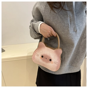 Détail du sac à main en forme de chat avec oreilles et dégradé rose porté à la main
