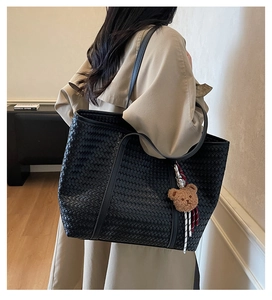 Grand sac cabas noir tissé avec pendentif ours en peluche marron porté à l'épaule