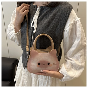 Détail d'un mini sac à main en forme de chat avec dégradé de rose et boucle métallique