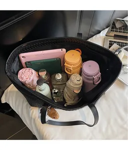Vue intérieure d'un grand sac cabas tressé noir montrant sa grande capacité de rangement