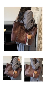 Détail d'un cabas en cuir tressé marron foncé avec breloque ours et corde contrastée