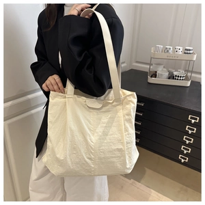Gros plan du sac cabas beige plissé en nylon avec une étiquette cousue Fashion