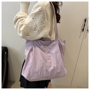Détail du sac fourre-tout en nylon lavande avec écusson en relief au fini froissé chic