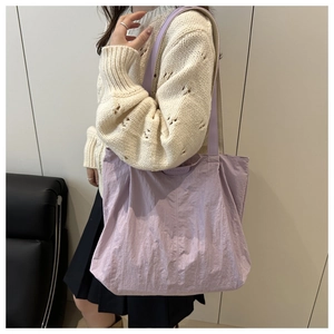 Détail du cabas violet clair avec étiquette mode et tissu plissé texturé