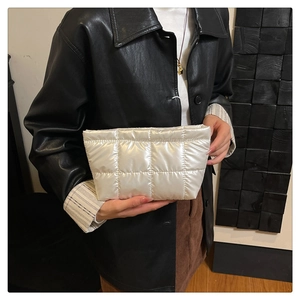 Détail d'une trousse de maquillage matelassée blanche en tissu imperméable brillant