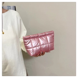 Detailed view of pink quilted handbag with metallic finish and zipper closure