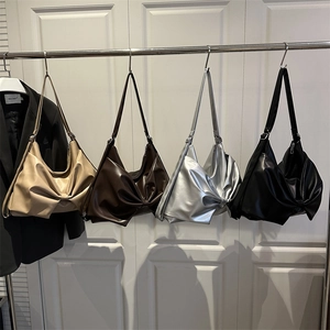 Borse a spalla con fiocco plissettato in beige, marrone, argento e nero appese in display