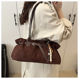 Detailansicht der dunkelbraunen Wildleder-Schultertasche mit Holzperlen und Gürtelschnalle
