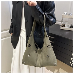 Détail d'un grand sac cabas en daim vert foncé avec motifs floraux découpés au laser