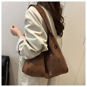 Detailed view of the dark brown suede tote bag with intricate floral laser-cut patterns
