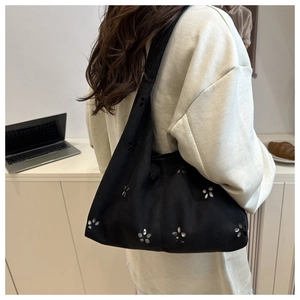 Détail du sac hobo noir avec fleurs découpées au laser et intérieur spacieux chic