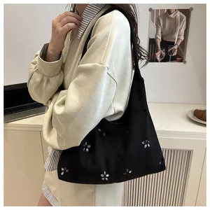 Detail of black laser-cut floral tote bag showing intricate hollow-out patterns