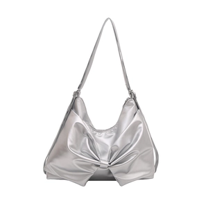 Borsa a spalla argento metallizzato con un grande fiocco decorativo su sfondo bianco