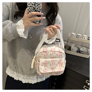 Détail du sac à bandoulière en velours côtelé avec motifs nœuds roses et texture tissu