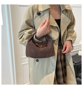 Detail of dark brown suede hobo bag with silver buckle and minimalist vintage style