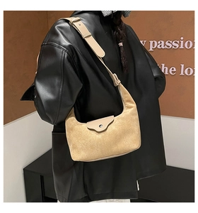 Close-up of khaki suede hobo bag with magnetic snap and smooth leather strap detail