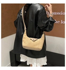 Detail of minimalist beige suede crossbody bag with premium leather flap and metal buckle