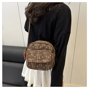 Sac bandoulière en velours côtelé marron à motifs nœuds, porté par un mannequin