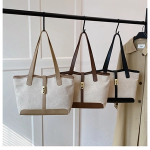 Trois sacs cabas en toile avec garniture en cuir et fermoir en métal sur support