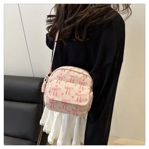 Détail d'un sac en velours côtelé rose avec motifs nœuds et tirette tissée