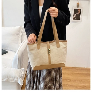 Détail du sac cabas en toile avec bordure en cuir et fermoir en métal doré