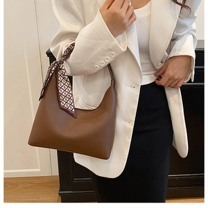 Brown leather hobo bag with printed silk scarf shown on model in minimalist office style