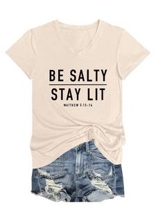 T-shirt rose col en V avec texte et short en jean déchiré disposés à plat sur fond blanc
