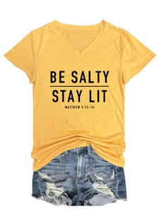 Détail du t-shirt jaune col V avec texte Be Salty Stay Lit et short en jean