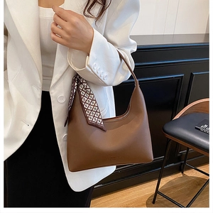 Sac hobo en cuir marron avec un foulard à carreaux élégant sur la bandoulière de l'épaule